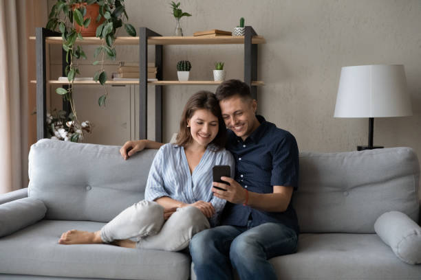 istock Happy affectionate couple using cellphone applications at home. 1415255915