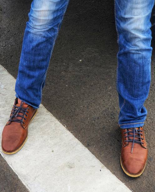 istock Man wearing blue denim jeans with brown leather shoes. 1415256021