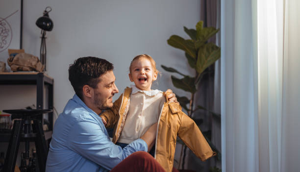 istock Happy Dad Getting His Daughter Ready to Go Outside 1415257235