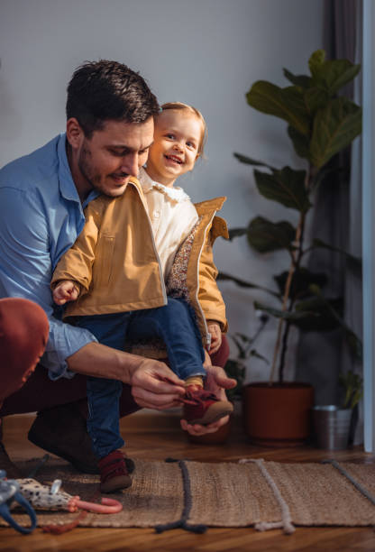 istock Happy Dad Getting His Daughter Ready to Go Outside 1415257242