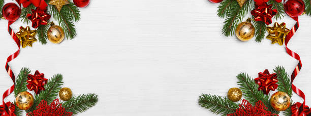 istock New Year greeting card web banner. Christmas tree branches with red and yellow balls on white wooden background close-up and copy space. 1415259302