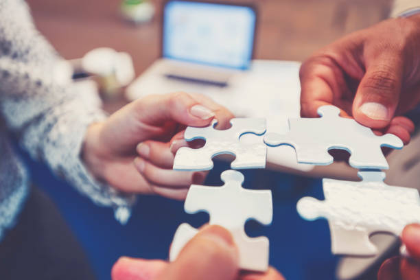 Group of business people holding a jigsaw puzzle pieces. stock photo