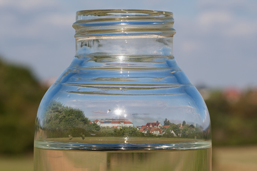 Dried up, a city reflected in a water bottle. The climate crisis is also draining water in Germany. Groundwater levels are falling and threatening the drinking water supply of the cities.