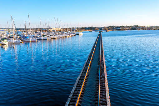 Aerial View of a railroad bridge over water next to a marina