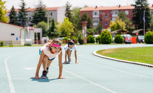 Little girls preparing for run on the running track