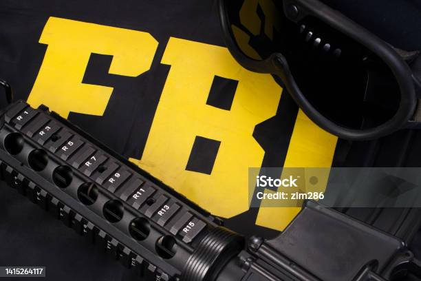 Assault Rifle And Protective Helm With Goggles On Fbi Raid Jacket Black Uniform Stock Photo - Download Image Now