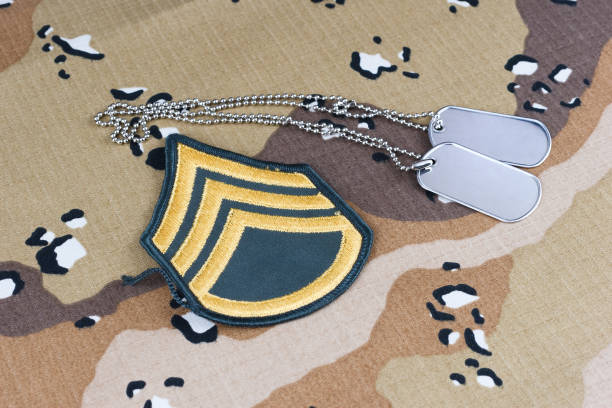 istock US ARMY Staff Sergeant rank patch and dog tags on Desert Battle Dress Uniform background 1415264172