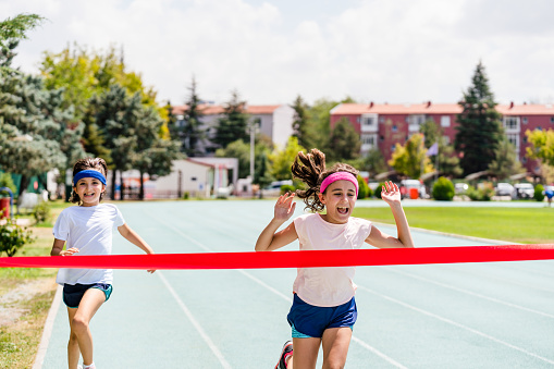 little girls crossing the finish line of a track race