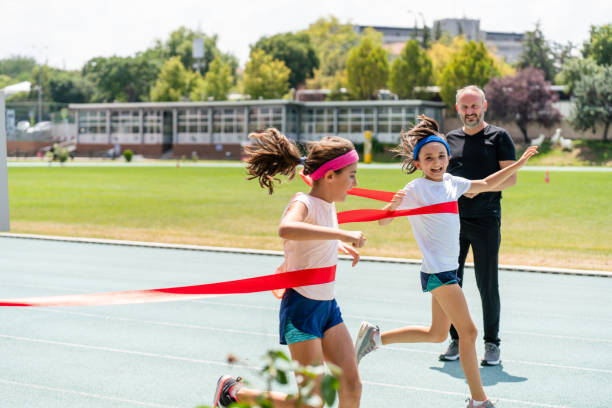 little girls crossing the finish line of a track race - 10 speed imagens e fotografias de stock