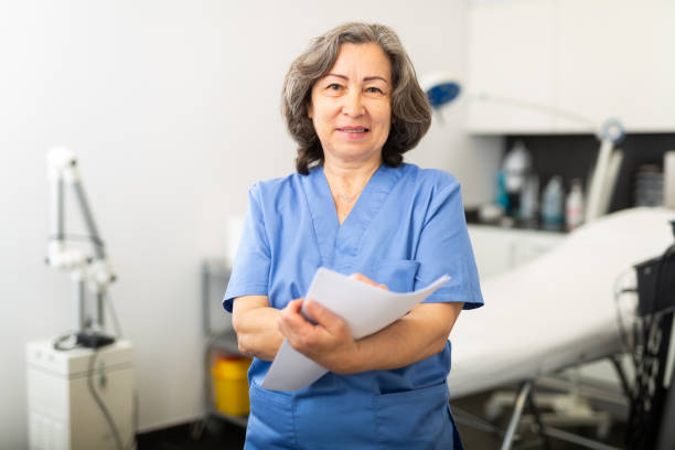 istock Focused nurse writing medical history on patient card 1415266541