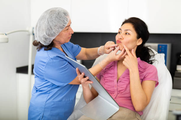istock Cosmetologist examining lips of female client before procedure 1415266547