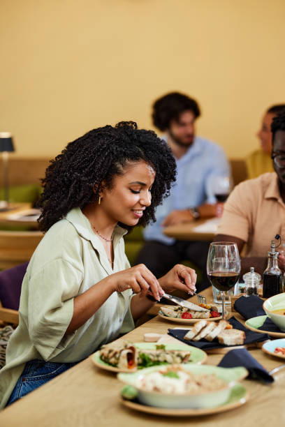 istock A Hispanic girl eats dinner in a restaurant. 1415269893