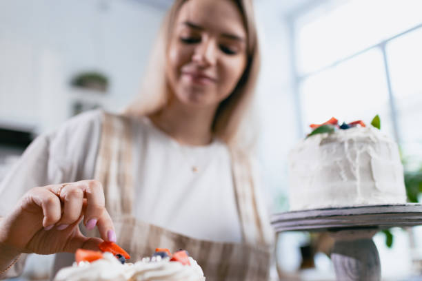 istock Pastry chef confectioner young caucasian woman with cake on kitchen table. 1415274457