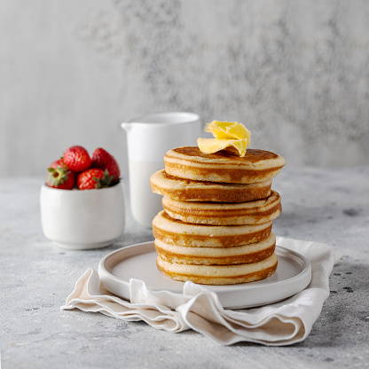 Classic American Pancakes tower with butter on the grey background. .