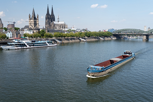 Cologne, Germany August 16, 2022: an unloaded cargo ship sails on the rhine in cologne at low water level