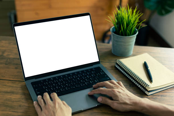 istock mock up empty screen notebook, businessman working on his laptop computer with blank space screen for advertising text on wood desk in Cafe 1415284275