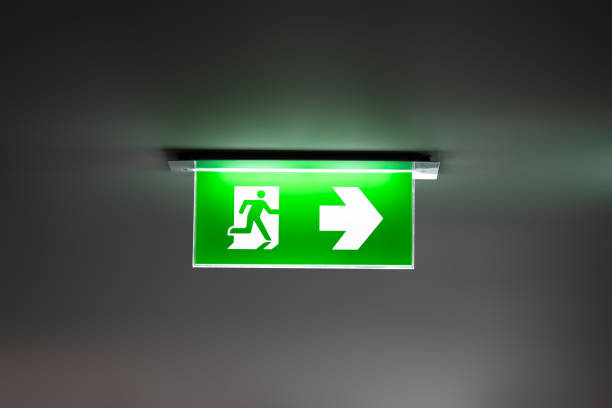 istock fire exit sign light box is hung on the ceiling in hotel walk way. 1415286944