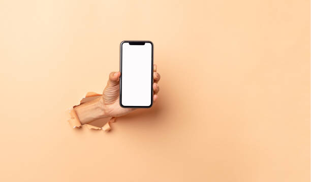 istock man hand holding a blank screen smart phone on a brown background 1415287587