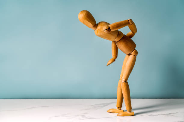 Concept of back pain. A wooden figure depicts a pain in the back. stock photo