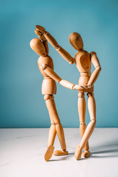 istock two wooden mannequins dancing and holding each other 1415287714