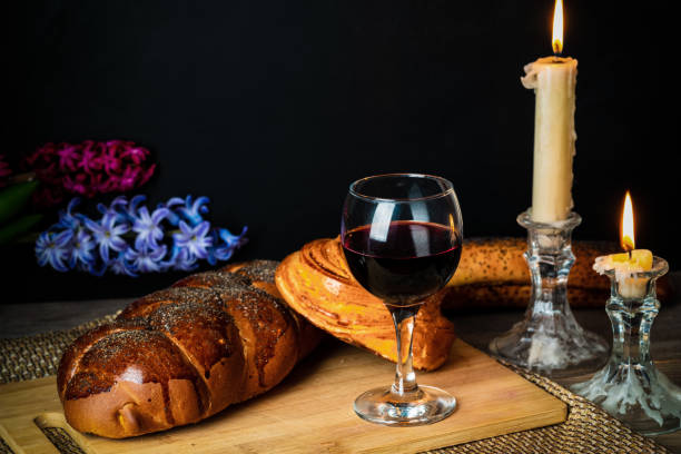 Shabbat Shalom. Challah bread, shabbat wine and candles on wooden table. stock photo