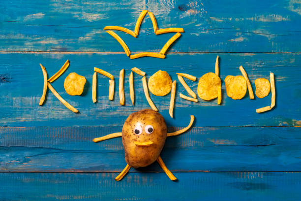 Koningsdag or Kings Day is a national holiday in the Kingdom of the Netherlands. Funny potato with eyes and in a tie on the background of the inscription Koningsdag stock photo