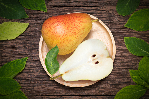 Fresh Pears with leaves on  a wooden background, Red Pears fruits delicious and sweet on wooden plate in wooden Background