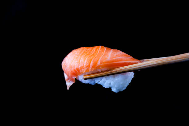 istock Salmon sushi by wooden chopsticks 1415295025