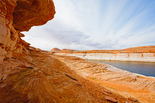 The Chains, Glen Canyon, Arizona. Red rocks, Lake Powell and cloudy sky background, copy space