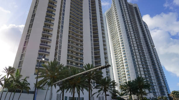 istock Modern apartment buildings with palm trees at Miami - view from road 1415297832