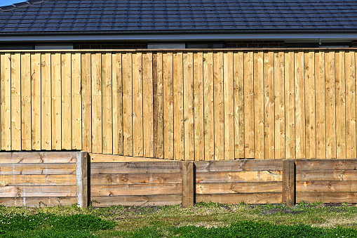 Pine sleeper retaining wall with a timber paling fence above it