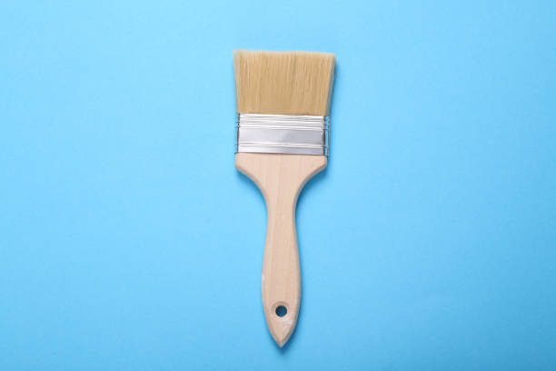 istock Paint brush with wooden handle on blue background 1415300331