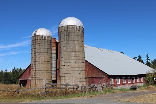 An old farm and barn with two silos