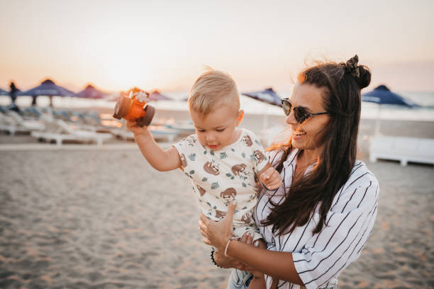 istock Young mother with her baby son playing at the beach 1415302030
