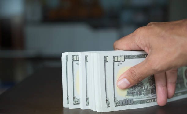 istock Finger giving Cash 100 Dollar Closeup 1415307352