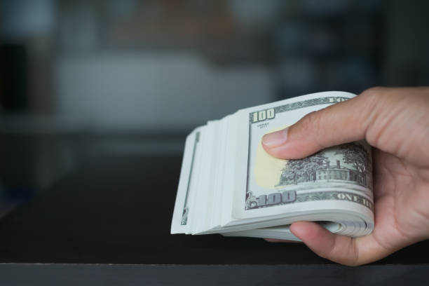 istock Finger giving Cash 100 Dollar Closeup. 1415307362