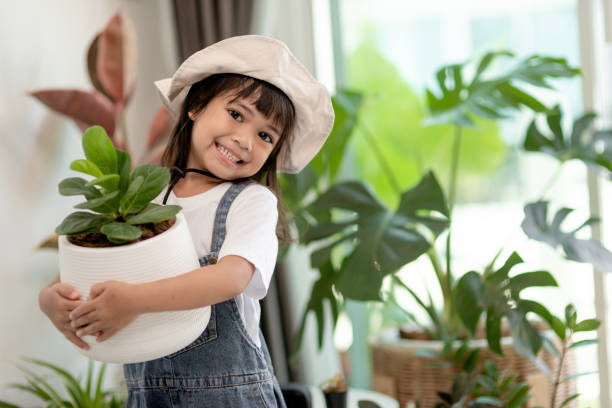 istock Potted plants at home held by a cute kid 1415310686