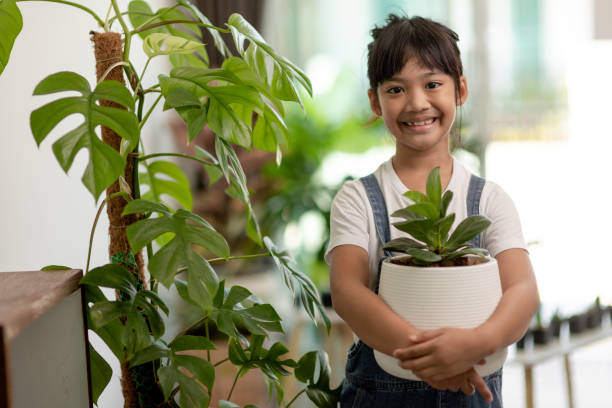 istock Potted plants at home held by a cute kid 1415311061