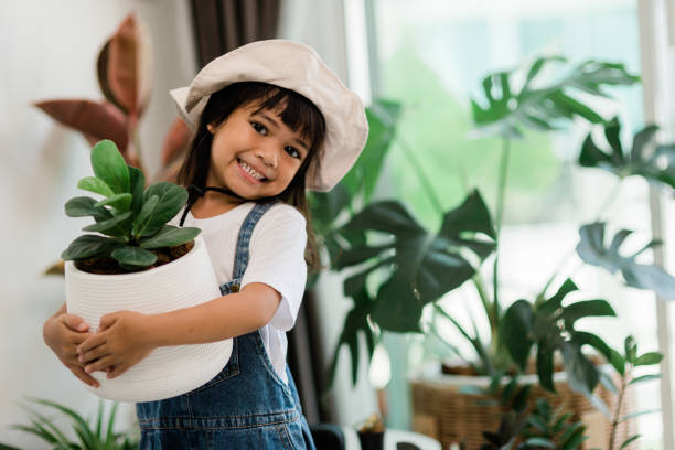 Potted plants at home held by a cute kid