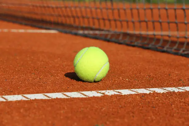 Symbol image tennis: Close-up of a tennis ball on a clay court
