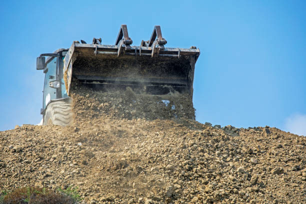 istock escalator bucket pours out clay soil. Global construction. Mining. 1415323888