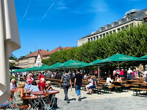 Bayreuth, Germany - August, 6 - 2022: Pedestrian zone in the old historic town, here the Maximilianstraße. Open air restaurants and beer gardens to be seen.
