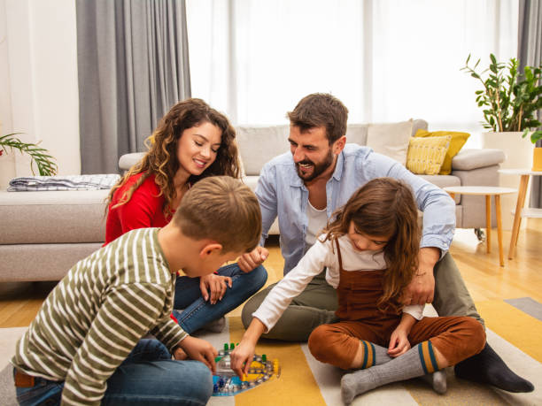 istock Cheerful parents playing board game with their children. 1415324380