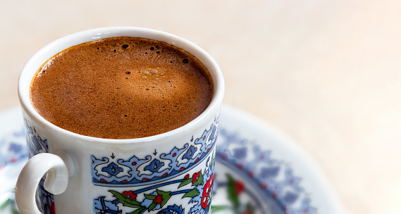 Top view photo of traditional Turkish coffee with bubbles on isolated white background.