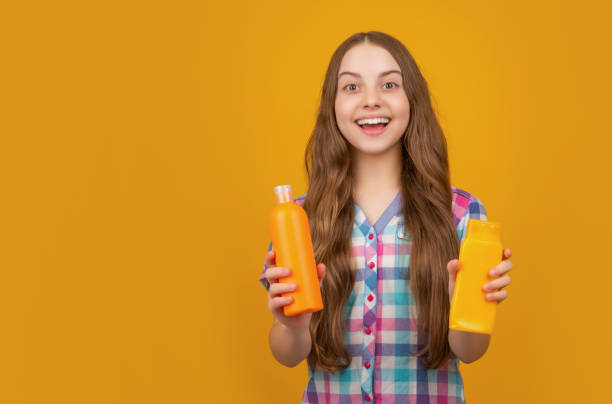 istock surprised child with shampoo bottle on yellow background 1415325406