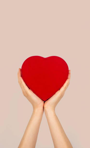 istock Hands holding heart shaped box with isolated background. 1415326524