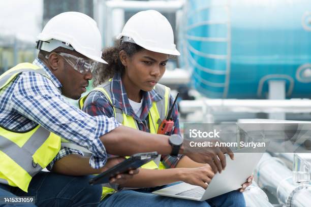 Group Of African American Engineer Working In Sewer Pipes Area At Construction Site Male Engineer And Woman Engineer Discussing For Maintenance Sewer Pipes Water Tank On Rooftop Of Building Stock Photo - Download Image Now