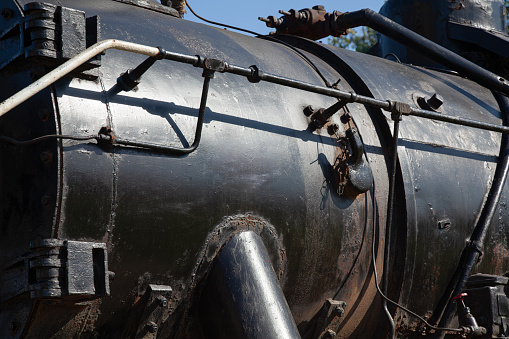 Close up of brass pipes on outside of steam locomotive.