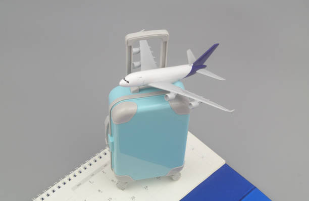 istock Calendar and airplane model on suitcase on gray background. Copy space for text. 1415332270