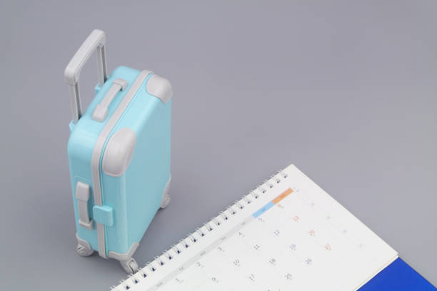 istock Calendar and suitcase on gray background. 1415332331